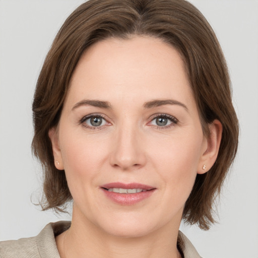 Joyful white young-adult female with medium  brown hair and grey eyes