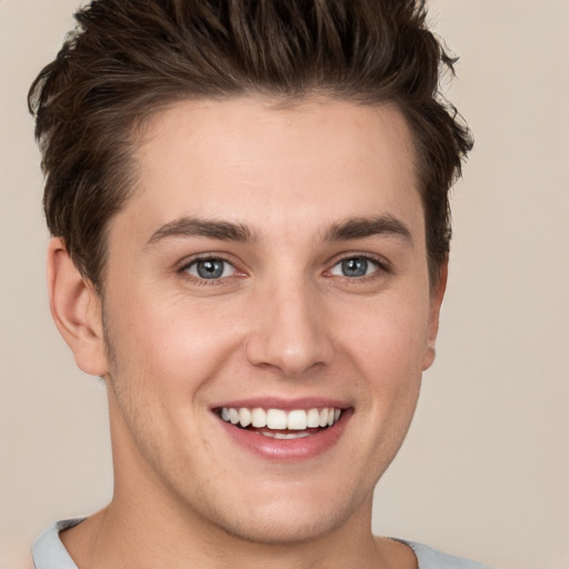 Joyful white young-adult male with short  brown hair and grey eyes