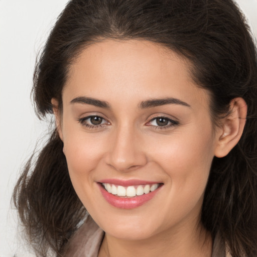 Joyful white young-adult female with long  brown hair and brown eyes