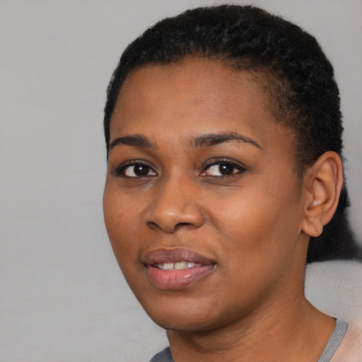 Joyful black young-adult female with short  black hair and brown eyes