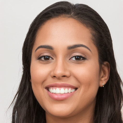 Joyful latino young-adult female with long  brown hair and brown eyes