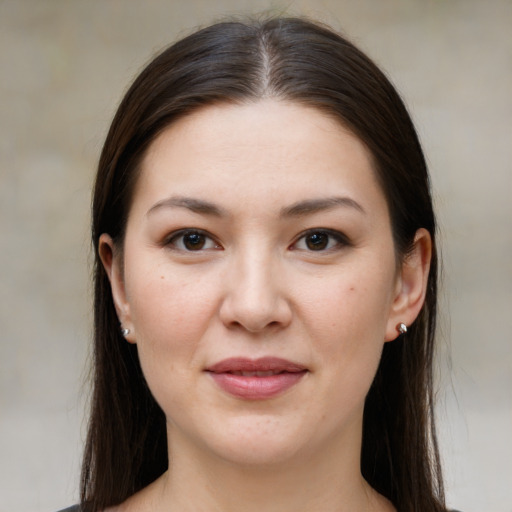 Joyful white young-adult female with long  brown hair and brown eyes