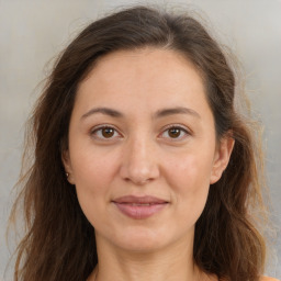 Joyful white adult female with long  brown hair and brown eyes