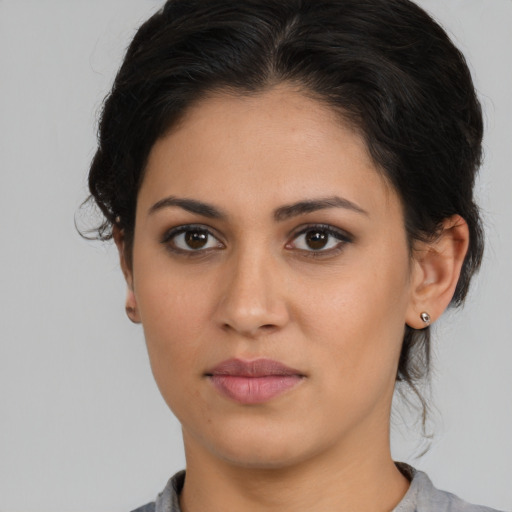 Joyful latino young-adult female with medium  brown hair and brown eyes