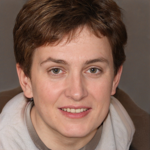 Joyful white young-adult male with medium  brown hair and grey eyes