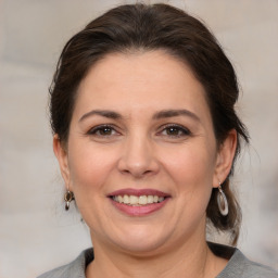 Joyful white adult female with medium  brown hair and brown eyes