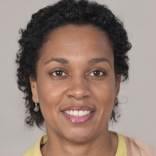 Joyful black adult female with short  brown hair and brown eyes