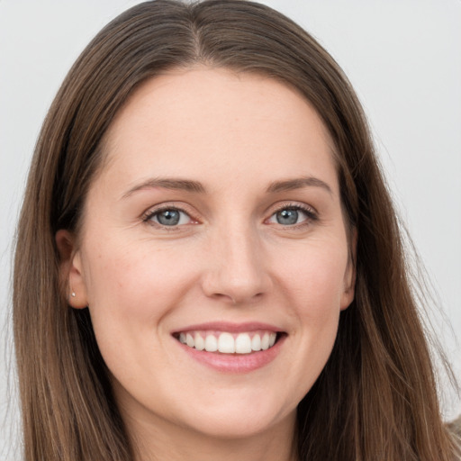 Joyful white young-adult female with long  brown hair and grey eyes