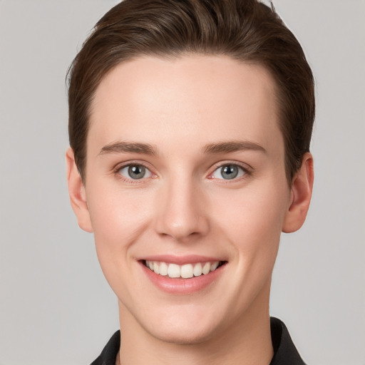 Joyful white young-adult female with short  brown hair and grey eyes