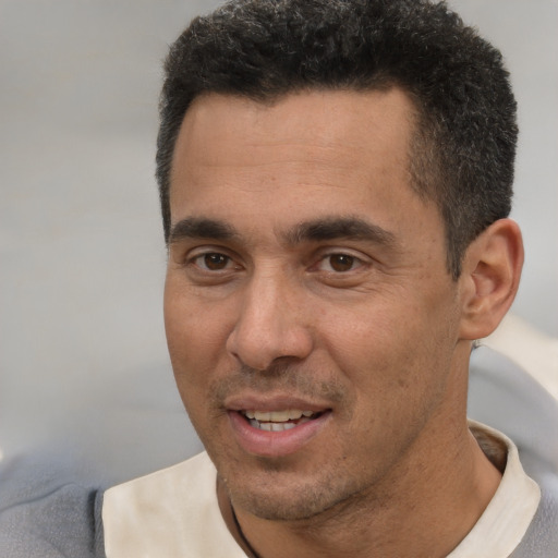 Joyful white adult male with short  black hair and brown eyes