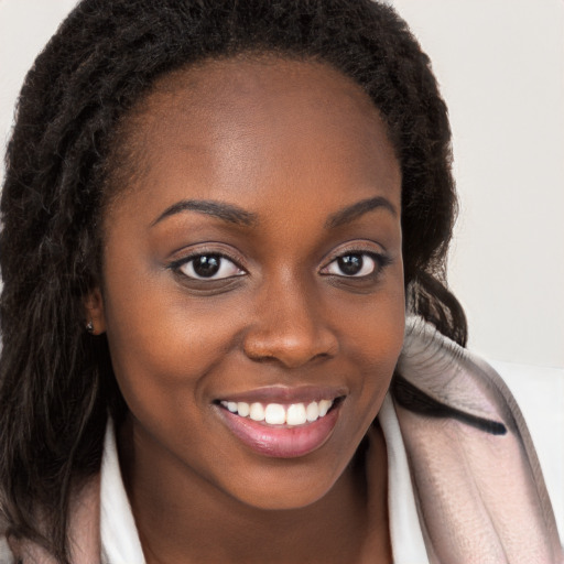 Joyful black young-adult female with long  brown hair and brown eyes