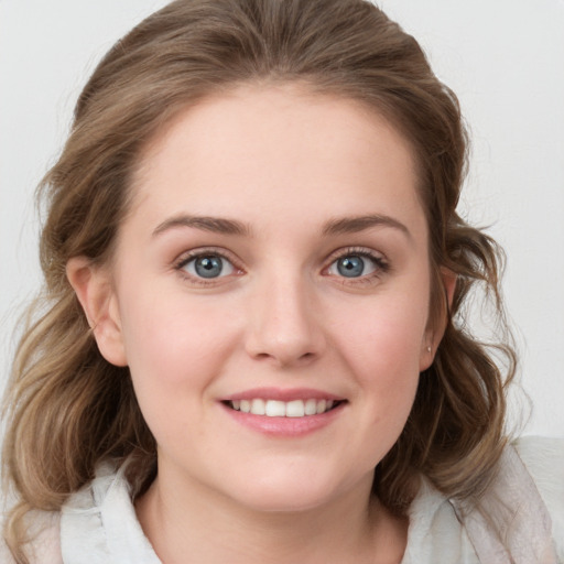 Joyful white young-adult female with medium  brown hair and blue eyes