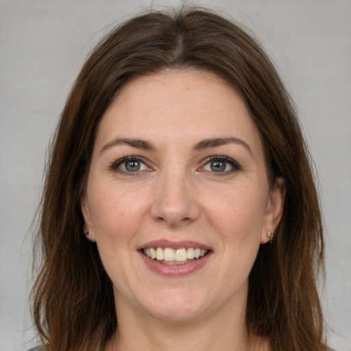 Joyful white young-adult female with medium  brown hair and grey eyes