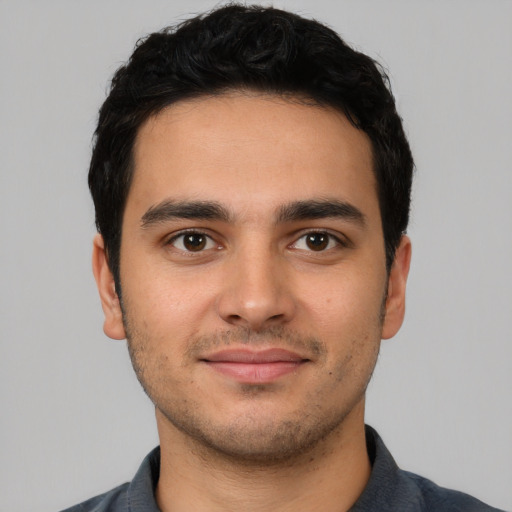 Joyful white young-adult male with short  black hair and brown eyes