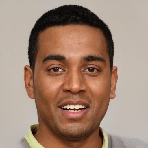 Joyful black young-adult male with short  black hair and brown eyes