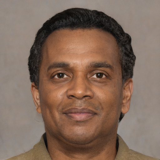 Joyful black adult male with short  black hair and brown eyes