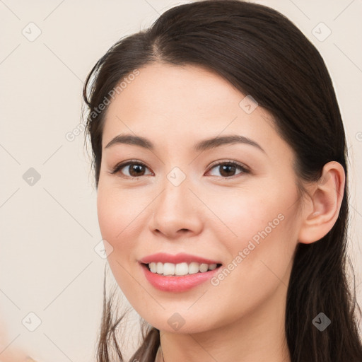 Joyful white young-adult female with long  brown hair and brown eyes