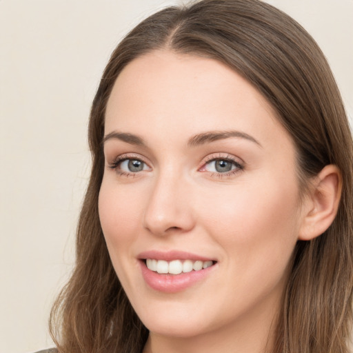 Joyful white young-adult female with long  brown hair and grey eyes