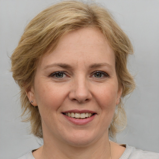 Joyful white adult female with medium  brown hair and blue eyes