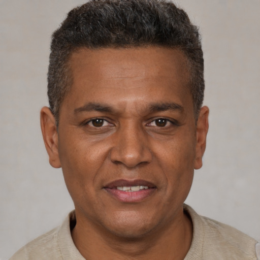 Joyful black adult male with short  brown hair and brown eyes