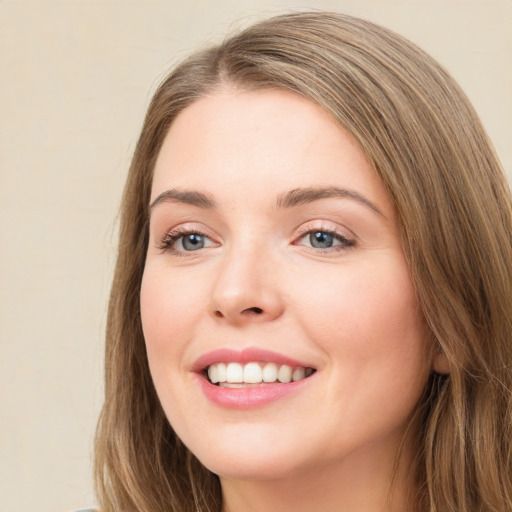 Joyful white young-adult female with long  brown hair and green eyes