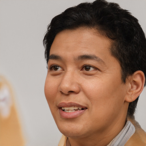 Joyful latino adult male with short  brown hair and brown eyes