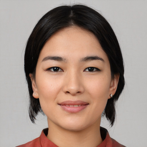 Joyful asian young-adult female with medium  black hair and brown eyes
