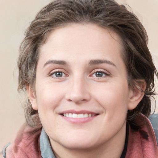 Joyful white young-adult female with medium  brown hair and blue eyes