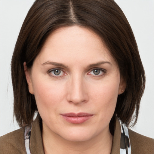 Joyful white young-adult female with medium  brown hair and grey eyes