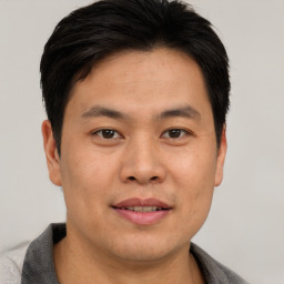 Joyful asian young-adult male with short  brown hair and brown eyes