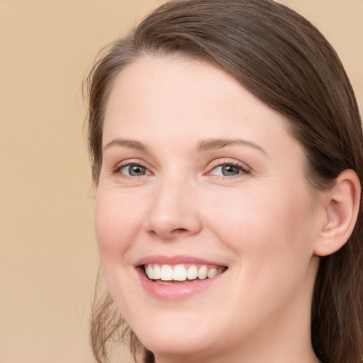 Joyful white young-adult female with long  brown hair and grey eyes