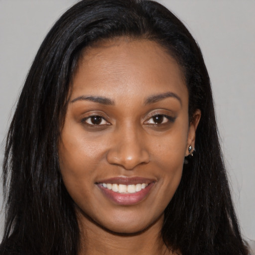 Joyful black young-adult female with long  brown hair and brown eyes