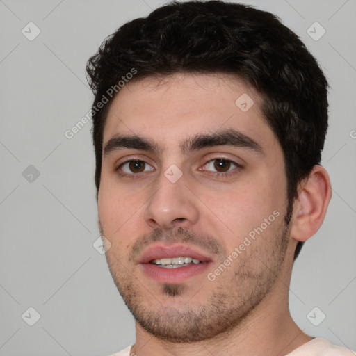 Joyful white young-adult male with short  black hair and brown eyes