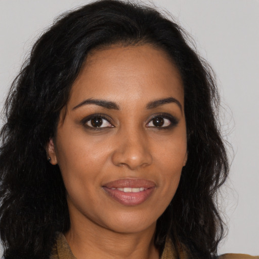 Joyful black young-adult female with long  brown hair and brown eyes