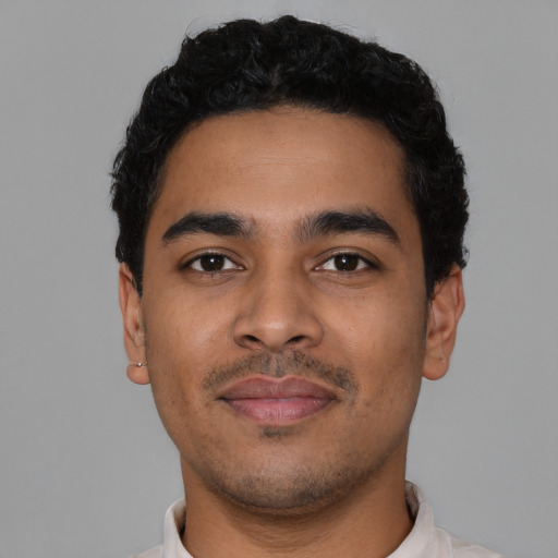 Joyful latino young-adult male with short  black hair and brown eyes