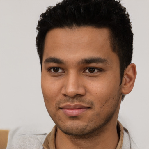 Joyful latino young-adult male with short  black hair and brown eyes