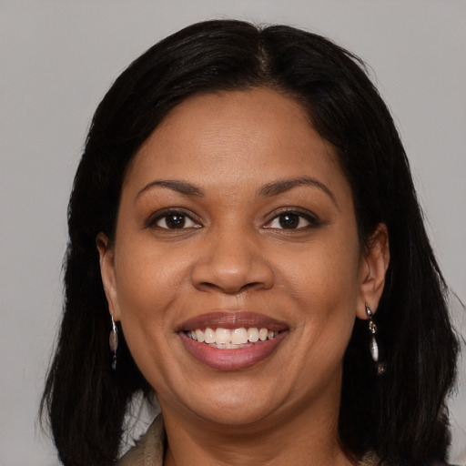 Joyful black young-adult female with long  brown hair and brown eyes