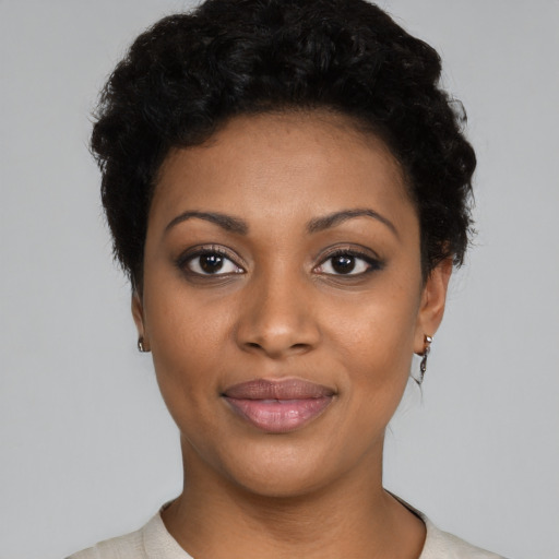 Joyful black young-adult female with short  black hair and brown eyes