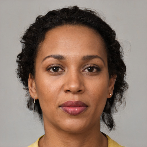 Joyful black adult female with medium  brown hair and brown eyes