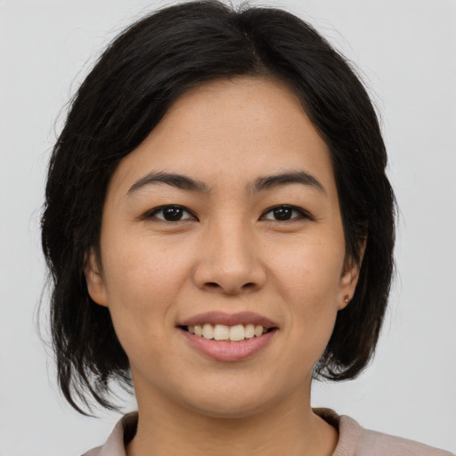 Joyful asian young-adult female with medium  brown hair and brown eyes