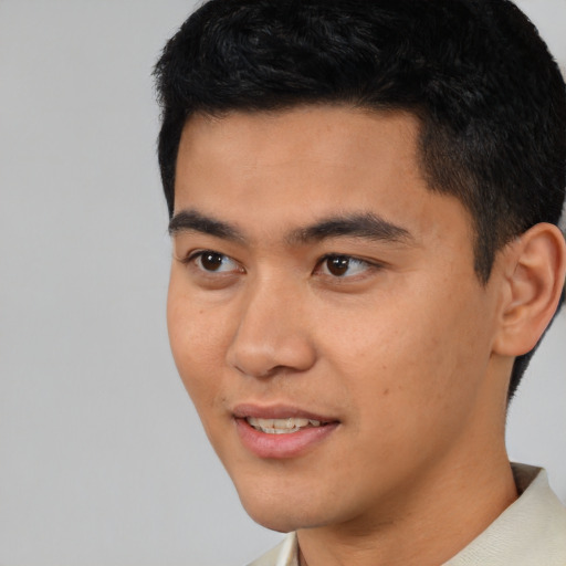 Joyful latino young-adult male with short  black hair and brown eyes