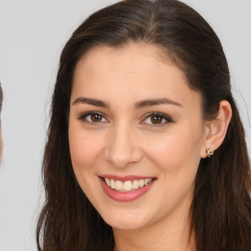 Joyful white young-adult female with long  brown hair and brown eyes