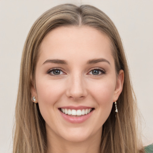 Joyful white young-adult female with long  brown hair and green eyes