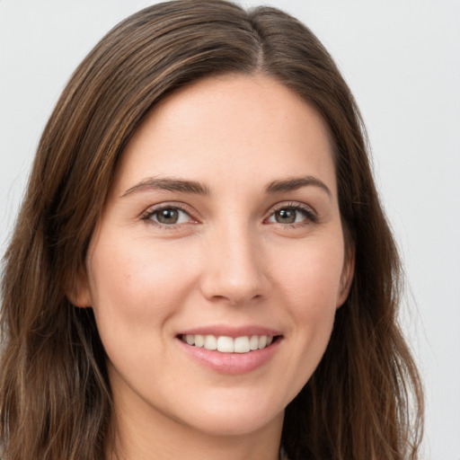 Joyful white young-adult female with long  brown hair and green eyes