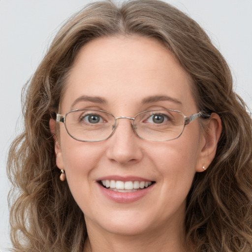 Joyful white adult female with long  brown hair and grey eyes