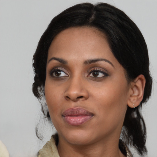 Joyful black adult female with medium  black hair and brown eyes