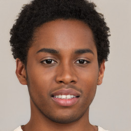 Joyful black young-adult male with short  brown hair and brown eyes