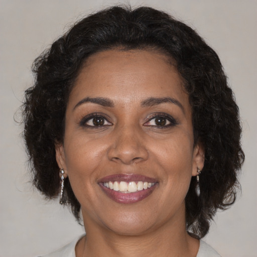Joyful black adult female with medium  brown hair and brown eyes
