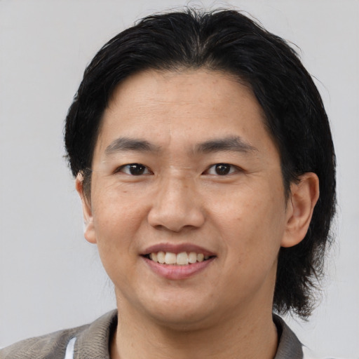 Joyful asian adult male with medium  black hair and brown eyes