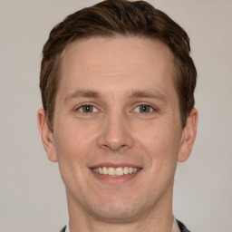 Joyful white adult male with short  brown hair and grey eyes